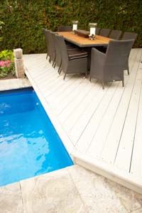 Patio furniture set on the deck beside an inviting pool